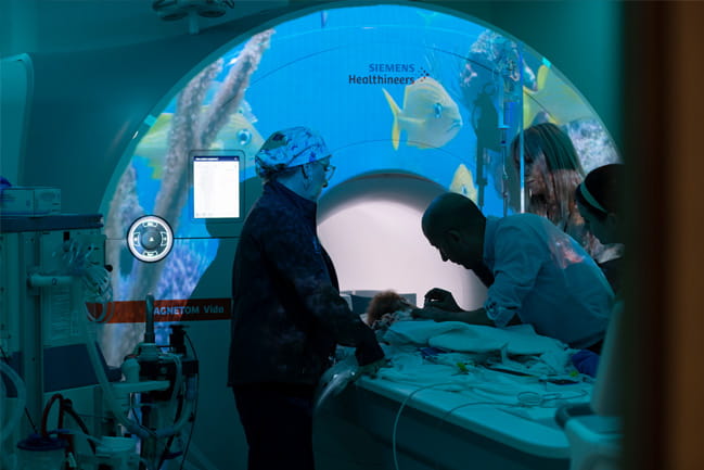 Health care workers tending to child in MRI machine 