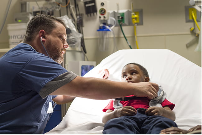 Photograph of Dr. Scott Russell examining patient.
